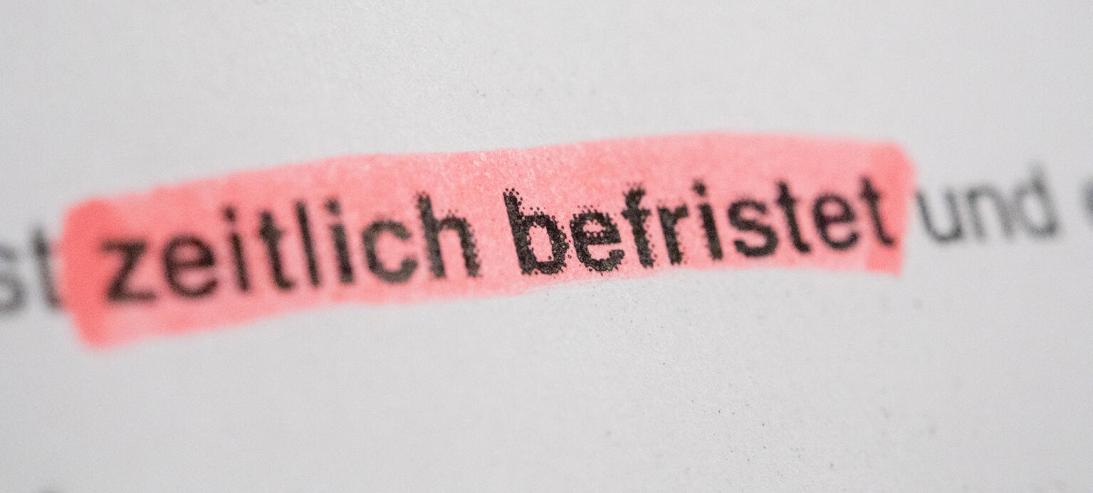 Ein Blatte Papier auf dem 'zeitlich befristet' steht. Diese Worte sind farbis markiert.