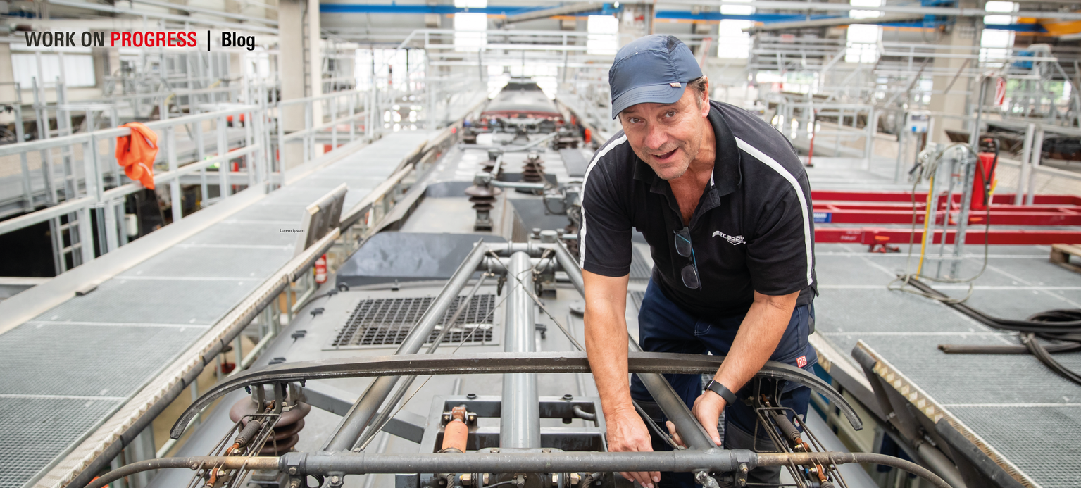 Klaus David, Elektriker in Rente bei der Deutschen Bahn, prüft auf einer Lokomotive im Nürnberger Bahnwerk den Stromabnehmer. Der 64-jährige arbeitet schon seit 49 Jahren bei der Deutschen Bahn, ist aber seit Anfang letzten Jahres im Ruhestand. Für ein paar Tage im Monat geht er weiter ins Werk. 